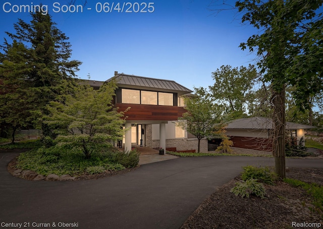 1985 Lone Pine Rd, Bloomfield Hills, MI 48302 - view of front of property with stone siding, driveway, metal roof, stucco siding, and a standing seam roof