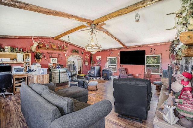living room featuring a ceiling fan, wood finished floors, and a wood stove