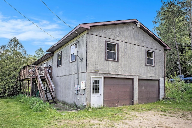 view of side of property with stairway, a deck, and driveway