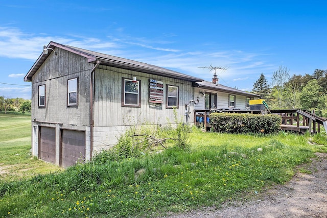 view of front of property with a garage, a wooden deck, and driveway