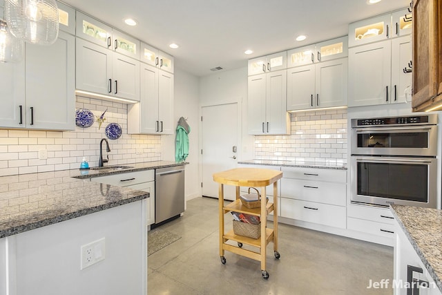 1525 W David Hwy, Ionia, MI 48846 - kitchen with appliances with stainless steel finishes, a sink, concrete floors, recessed lighting, and decorative backsplash