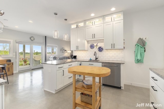1525 W David Hwy, Ionia, MI 48846 - kitchen with stainless steel dishwasher, a sink, a peninsula, backsplash, and white cabinetry