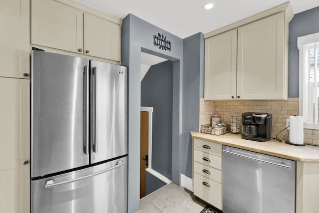 kitchen featuring appliances with stainless steel finishes, light countertops, backsplash, light tile patterned flooring, and recessed lighting