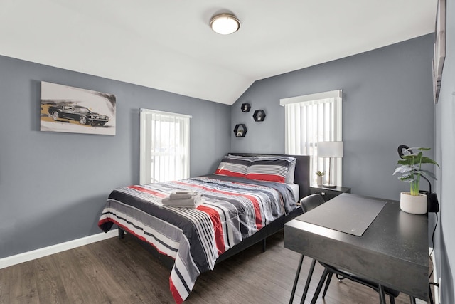 bedroom featuring lofted ceiling, wood finished floors, and baseboards