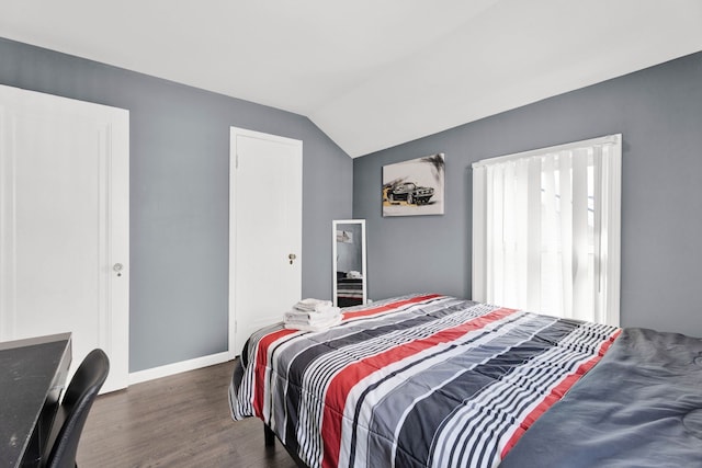 bedroom featuring wood finished floors, lofted ceiling, and baseboards