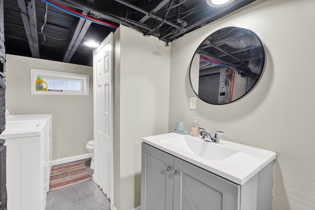 bathroom with separate washer and dryer, vanity, toilet, and baseboards