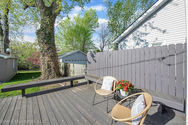 wooden deck featuring an outdoor structure and fence