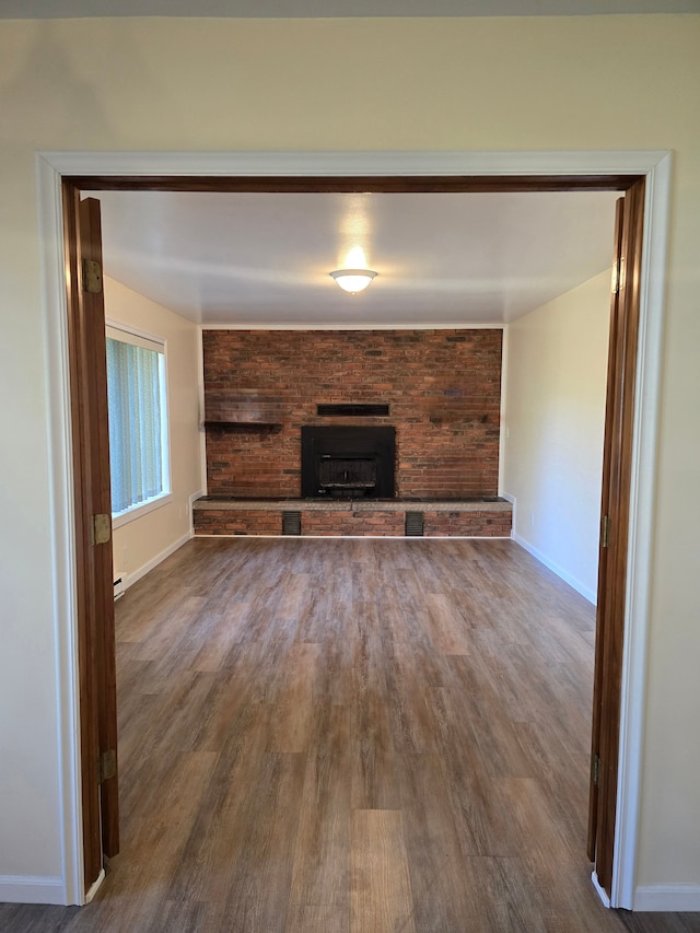 7400 Willow, Lexington, MI 48450 - unfurnished living room with wood finished floors, baseboards, and a brick fireplace