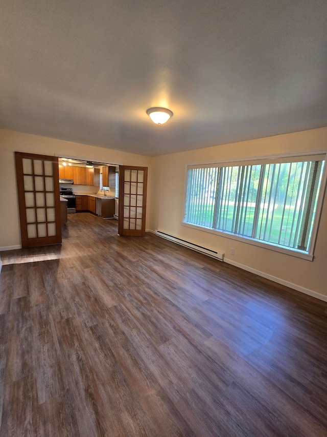 7400 Willow, Lexington, MI 48450 - unfurnished living room featuring a baseboard heating unit, dark wood-style flooring, baseboards, and a sink