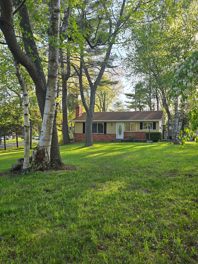7400 Willow, Lexington, MI 48450 - view of front of home featuring a chimney, a front lawn, and brick siding