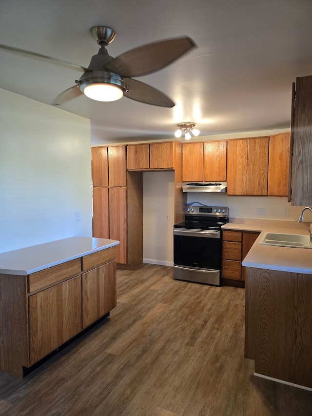 7400 Willow, Lexington, MI 48450 - kitchen with stainless steel electric range oven, a sink, brown cabinetry, dark wood-style floors, and a ceiling fan