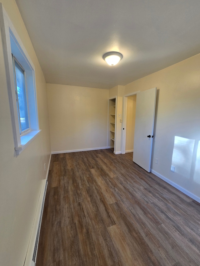 7400 Willow, Lexington, MI 48450 - unfurnished bedroom with dark wood-type flooring, a baseboard radiator, and baseboards