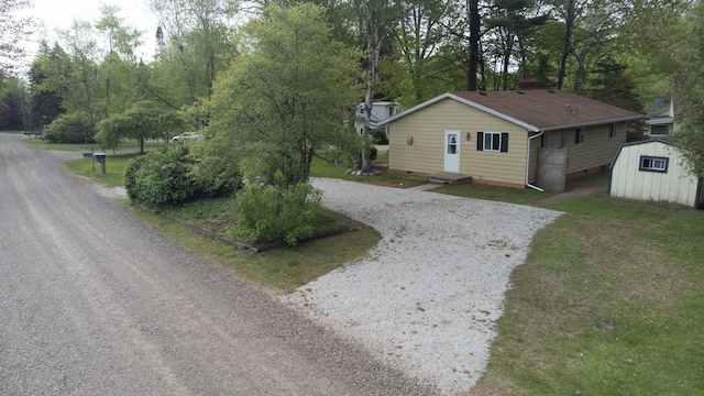 7400 Willow, Lexington, MI 48450 - view of front facade with a storage unit, an outdoor structure, driveway, and view of scattered trees