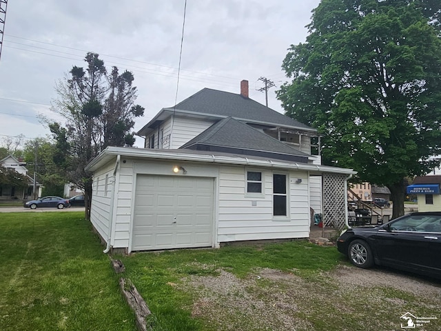 rear view of property with a yard, driveway, and a chimney