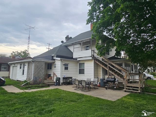 back of property with a patio, a lawn, and a chimney
