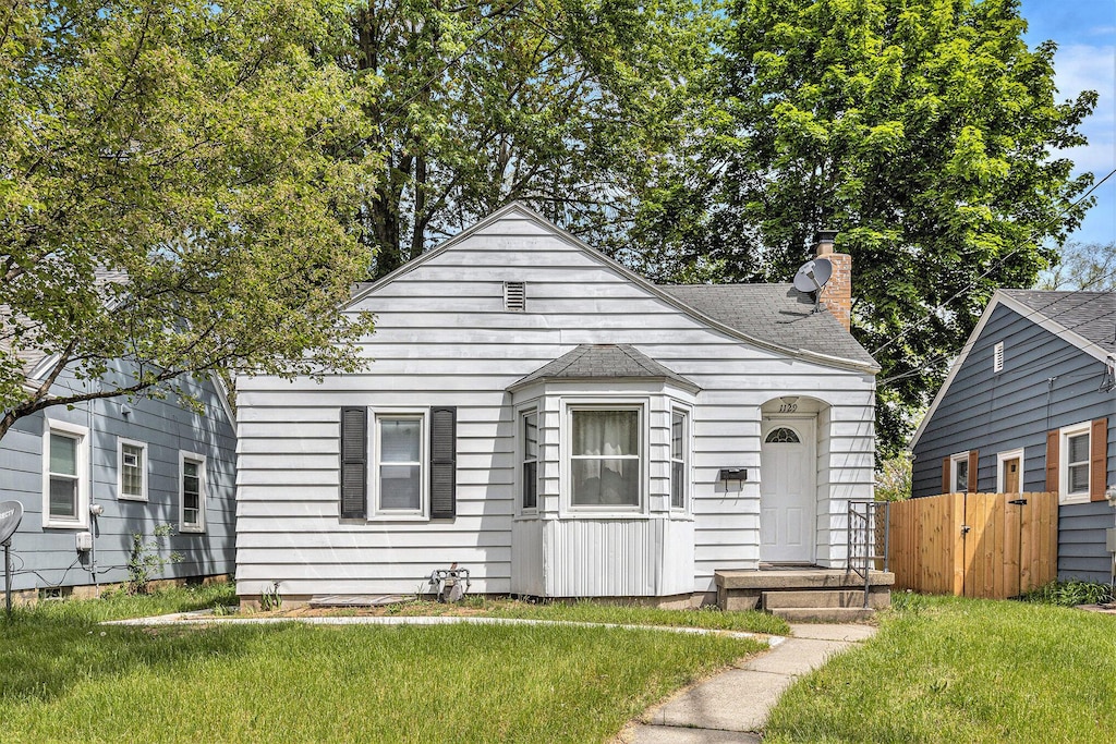 bungalow-style house with a chimney and a shingled roof