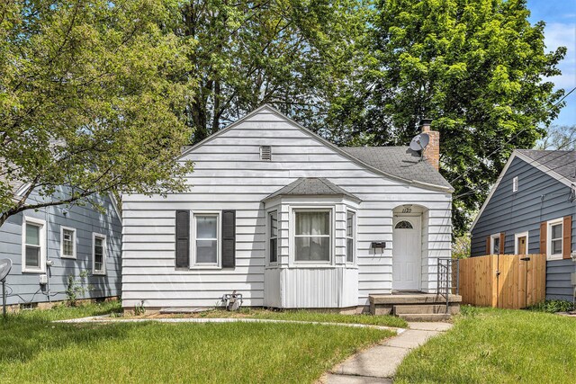 bungalow-style house with a chimney and a shingled roof