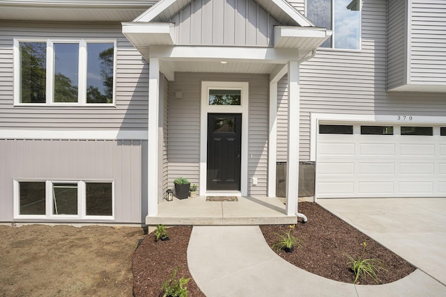 370 Chopin Dr, Muskegon, MI 49442 - property entrance featuring board and batten siding, a garage, and driveway