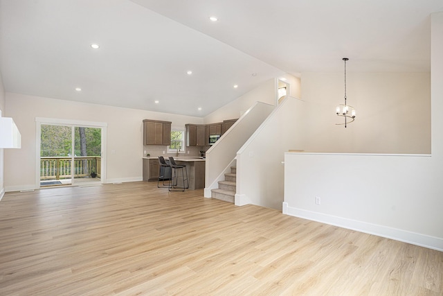 370 Chopin Dr, Muskegon, MI 49442 - unfurnished living room with light wood-style floors, recessed lighting, stairway, baseboards, and a chandelier