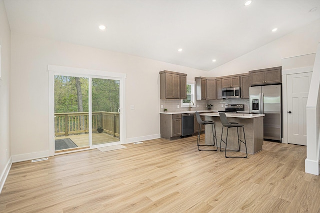 370 Chopin Dr, Muskegon, MI 49442 - kitchen featuring stainless steel appliances, light countertops, a center island, backsplash, and light wood-style floors