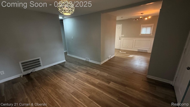 648 W Hazelhurst St, Ferndale, MI 48220 - empty room with a chandelier, dark wood-style floors, and baseboards