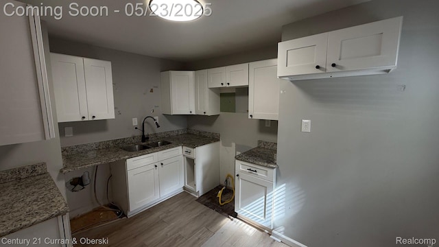 648 W Hazelhurst St, Ferndale, MI 48220 - kitchen with a sink, wood finished floors, white cabinetry, and light stone counters