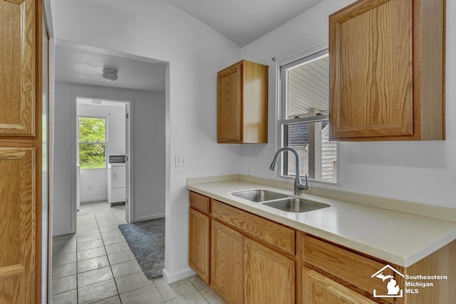 7316 Summerfield Rd, Lambertville, MI 48144 - kitchen with a sink, washer / clothes dryer, light countertops, baseboards, and brown cabinets