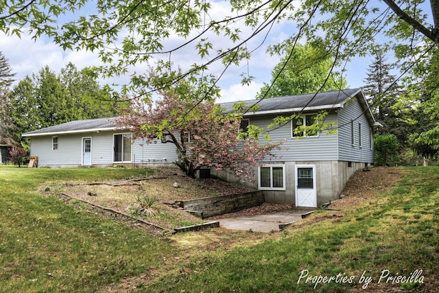 315 Hayes St NW, Comstock Park, MI 49321 - rear view of house with a lawn and a patio area