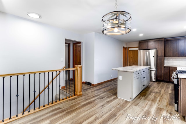315 Hayes St NW, Comstock Park, MI 49321 - kitchen featuring appliances with stainless steel finishes, light wood finished floors, a chandelier, a kitchen island, and recessed lighting