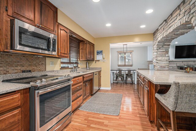 1514 Ferndale Blvd, Niles, MI 49120 - kitchen with stainless steel appliances, a sink, light wood-style flooring, backsplash, and light stone counters
