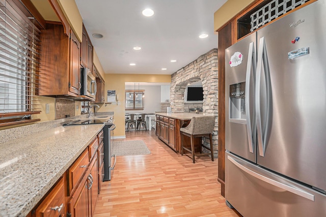 1514 Ferndale Blvd, Niles, MI 49120 - kitchen with appliances with stainless steel finishes, light wood finished floors, recessed lighting, light stone counters, and brown cabinetry