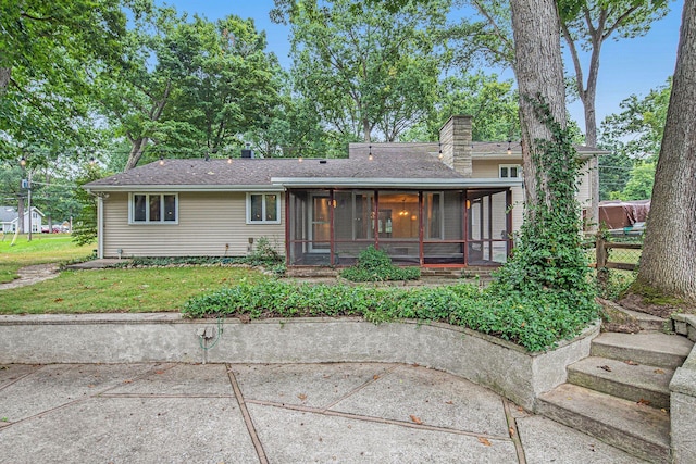 1514 Ferndale Blvd, Niles, MI 49120 - view of front of property with a sunroom, a chimney, a patio area, a front yard, and a shingled roof