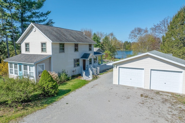 2220 Grass Lake Ave, Lake, MI 48632 - view of property exterior featuring a shingled roof, an outdoor structure, a water view, a sunroom, and a detached garage