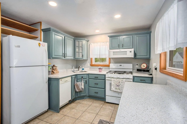 kitchen with white appliances, a sink, light countertops, light tile patterned floors, and recessed lighting