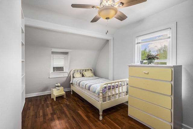 bedroom featuring wood finished floors, multiple windows, vaulted ceiling, baseboards, and a ceiling fan