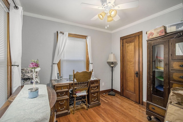 home office featuring light wood-style floors, ceiling fan, ornamental molding, and baseboards