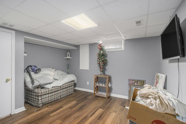sitting room with a drop ceiling, wood finished floors, and baseboards