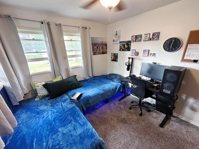 carpeted bedroom featuring ceiling fan and an office area