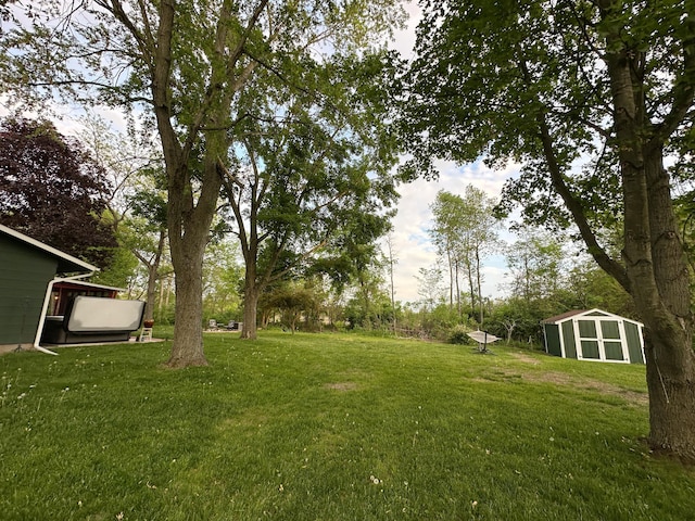 view of grassy yard featuring a shed and an outbuilding