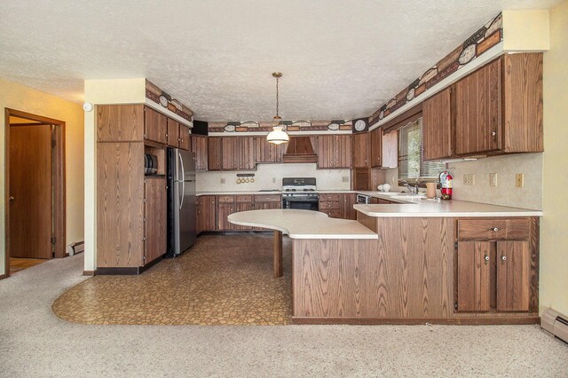 929 S Washington Ave, Ludington, MI 49431 - kitchen featuring freestanding refrigerator, gas stove, a peninsula, light countertops, and a textured ceiling