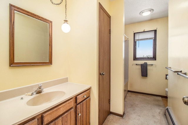 929 S Washington Ave, Ludington, MI 49431 - bathroom featuring a baseboard radiator, toilet, vanity, and baseboards