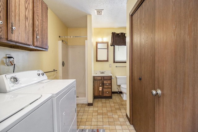 929 S Washington Ave, Ludington, MI 49431 - clothes washing area featuring washing machine and dryer, a textured ceiling, a sink, and baseboards