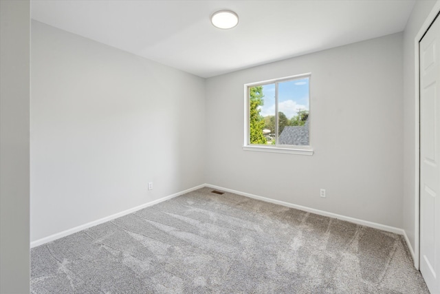 carpeted empty room featuring baseboards