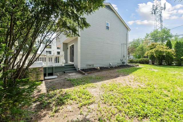 view of home's exterior with a lawn and a deck