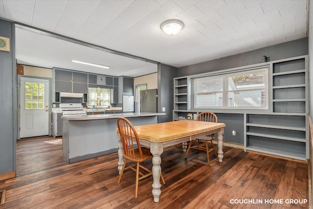 dining area with dark wood-type flooring and built in shelves