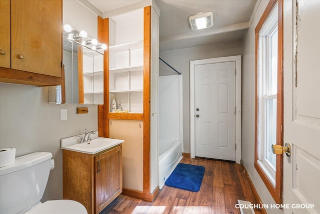 bathroom featuring wood finished floors, toilet, vanity, and bathtub / shower combination