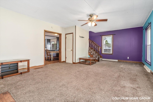unfurnished living room with stairway, ceiling fan, carpet, and baseboards