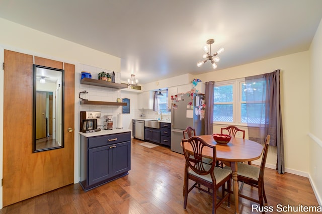 1572 Cornell Rd, Muskegon, MI 49441 - dining area with a chandelier, wood finished floors, and baseboards