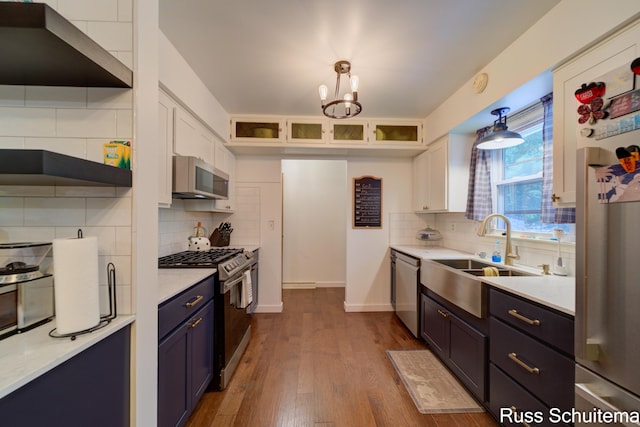 1572 Cornell Rd, Muskegon, MI 49441 - kitchen with stainless steel appliances, a sink, backsplash, dark wood-style floors, and a chandelier