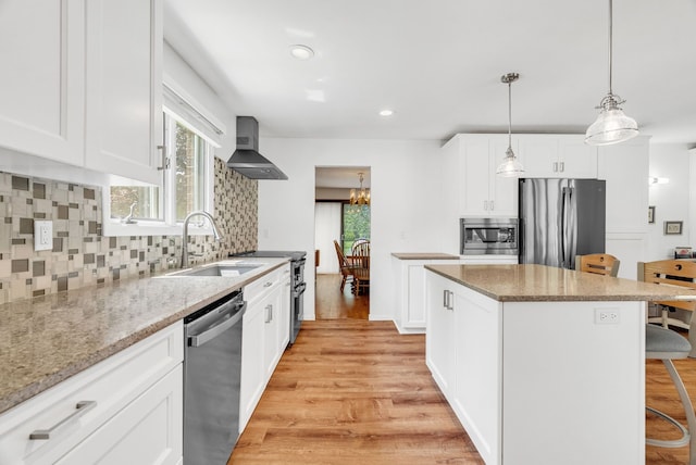 836 Boutell Dr, Grand Blanc, MI 48439 - kitchen featuring appliances with stainless steel finishes, a sink, wall chimney exhaust hood, a breakfast bar, and light wood-style floors